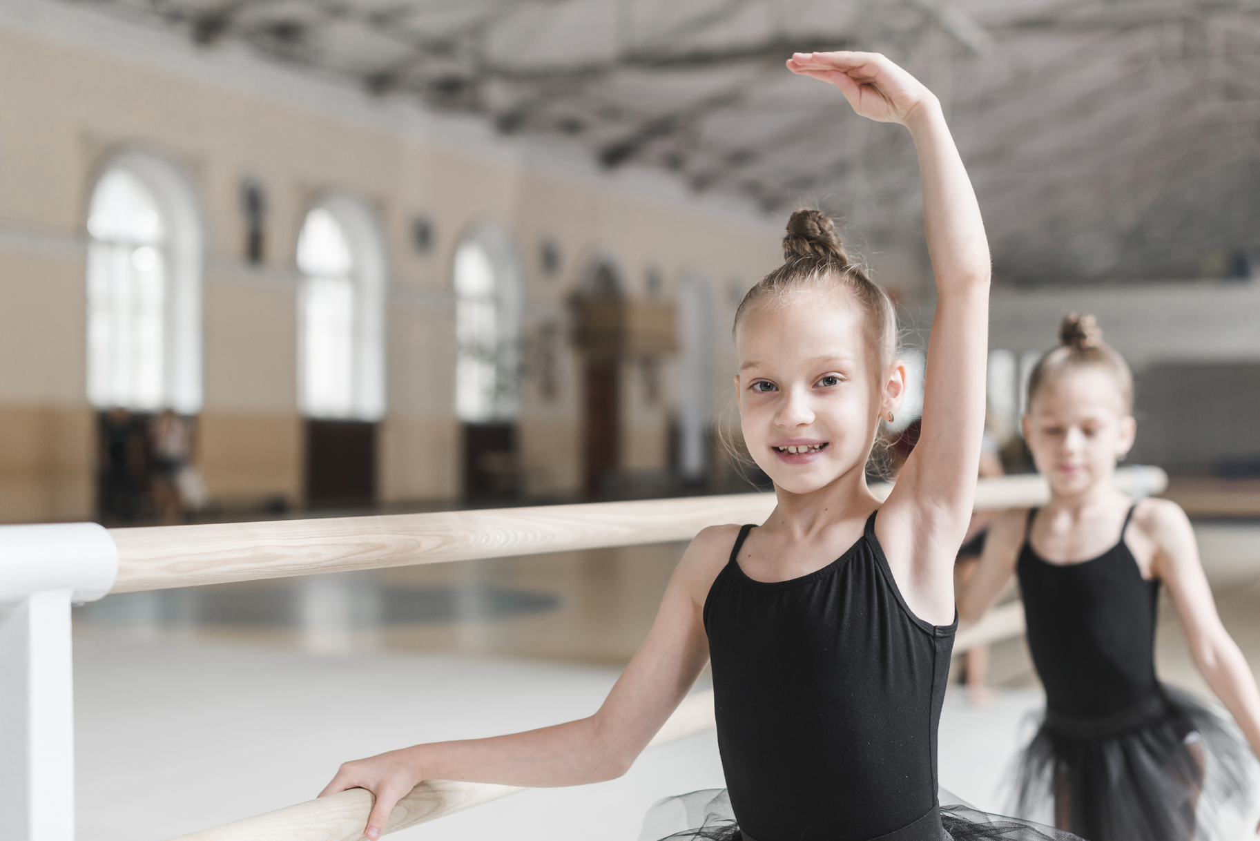 smiling-ballet-dancer-practicing-with-barre-dance-class